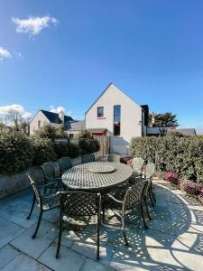 a patio with a table and chairs in front of a house at Maytown Villa in Tagoat