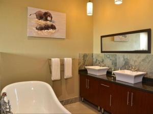 a bathroom with a bath tub and two sinks and a bath tub at Mjejane River Lodge in Hectorspruit +73 photos