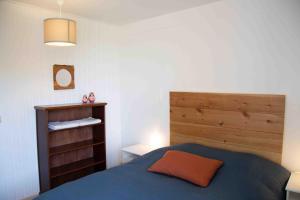 a bedroom with a blue bed and a wooden headboard at Les Soleils in Mérinchal