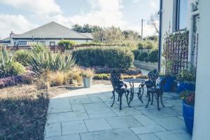 d'une terrasse avec 3 chaises et une table dans la cour. dans l'établissement Maytown Villa, à Tagoat