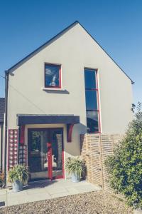 une maison blanche avec des plantes en pot devant elle dans l'établissement Maytown Villa, à Tagoat