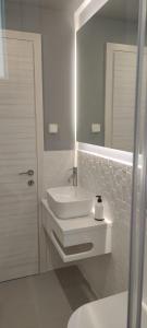 a white bathroom with a sink and a mirror at By The Sea - Paleros in Paleros