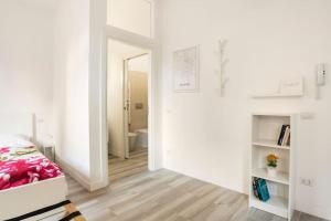 a white bedroom with a bed and a bathroom at AfforiCentro in Milan
