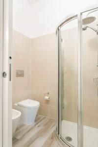 a bathroom with a toilet and a glass shower at AfforiCentro in Milan +27 photos