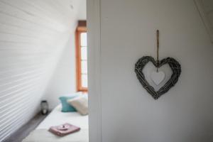 a heart hanging on a wall in a bedroom at Erdő Lelke Vendégház: mesebeli, erdőszéli faház panorámával in Nagymaros