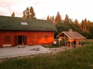 un gran edificio rojo con un cenador en un campo en CRYSTAL CLEAR AIR, TRANQUILITY & STUNNING SUNSETS en Vlăhiţa