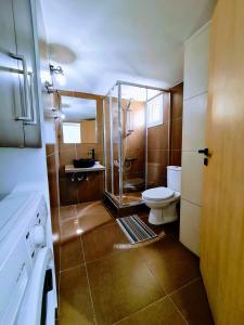 a bathroom with a toilet and a glass shower at Ayia Anna Apartment in Ayia Napa