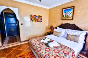 a bedroom with a bed and a blue door at Riad Mimouna in Essaouira