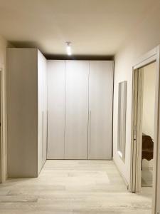 an empty room with white cabinets and a door at Front Beach Deluxe Apartment - with access to beach club in Viareggio