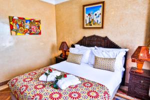 a bedroom with a bed with white sheets and pillows at Riad Mimouna in Essaouira