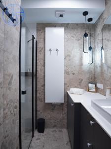 a bathroom with a shower and a sink and a mirror at Apartament na wydmie - Porto Łeba in Łeba