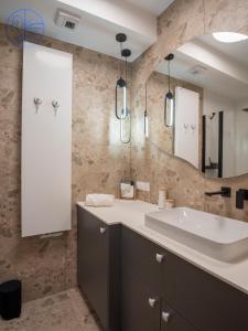 a bathroom with a sink and a large mirror at Apartament na wydmie - Porto Łeba in Łeba