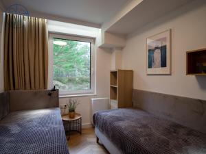 een slaapkamer met 2 bedden en een raam bij Apartament na wydmie - Porto Łeba in Łeba