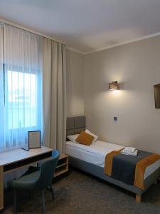 a hotel room with a bed and a desk with a laptop at Leśne Niebo in Lubniewice