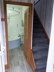 a bathroom with a staircase and a bath tub and a bathroom with a stairway at Poppy's Place Annex in Camelford North Cornwall in Camelford +6 photos