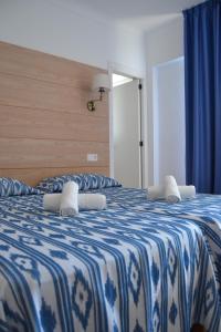 a bedroom with two beds with blue and white sheets at Hotel Vista Sol Cala Rajada in Cala Ratjada +35 photos
