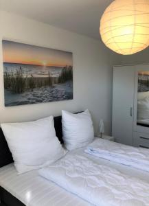 ein Schlafzimmer mit einem Bett mit weißen Kissen in der Unterkunft Haus Seebad Whg 11 in Grömitz