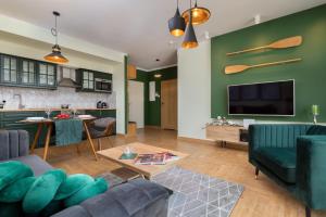 ein Wohnzimmer mit einem Sofa und einem TV in der Unterkunft Grano Green Comfort Residence by Renters Prestige in Danzig