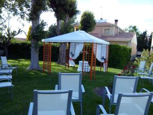 a group of chairs and a gazebo in a yard at Hostal Restaurante Carolina in Pedrosillo el Ralo