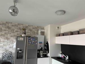 a kitchen with a refrigerator and a brick wall at Katy in Tournon-sur-Rhône