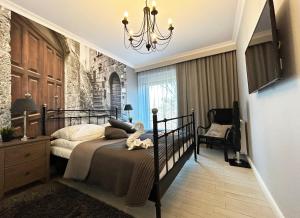 1 dormitorio con cama y lámpara de araña en Promenada Gwiazd by Baltic Home, en Międzyzdroje