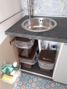 szafka łazienkowa z umywalką i koszami pod nią w obiekcie Bilocale in Lecce w mieście Lecce