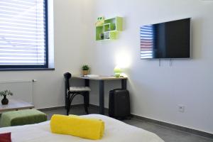 a room with a bed and a desk and a tv at New Pension at ROTOR Brewery in Kunovice