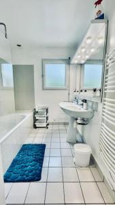 La salle de bains est pourvue d'un lavabo, d'une baignoire, de toilettes et d'un miroir. dans l'établissement Steredenn vor - L'étoile de Mer, à Roscanvel