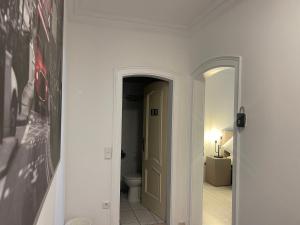 a hallway with a bathroom with a toilet and a picture at Goldfinger Party wg.1 in Cologne