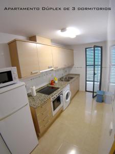 a kitchen with a white refrigerator and a microwave at La PARRETA CENTRO in Vinaròs