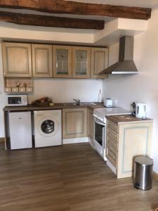 a kitchen with a stove and a washer and dryer at Le Petit Nid in Lesterps