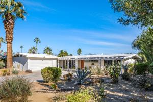 a house with a palm tree in front of it at Mirage Cove in Rancho Mirage