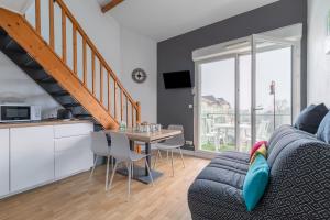 Il dispose d'une cuisine et d'un salon avec une table et un canapé. dans l'établissement Appart pour 4 - Piscine - Au coeur de La Chaume, à Les Sables-dʼOlonne