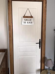 une porte blanche avec un panneau de vente de grange dans l'établissement Le Petit Nid, à Lesterps