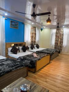 two beds in a room with blue walls and wooden floors at Hotel Young Mamta in Srinagar