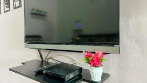 a mirror and a vase with flowers on a table at Mahkota Aman Guest House - 5pax in Kuantan