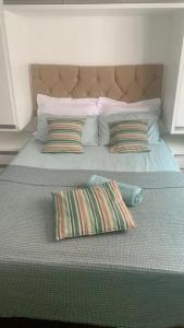 a large bed with two pillows on top of it at Studio expo norte Bras SP feira da madrugada Piscina Aquecida e Estacionamento Gratuito in Sao Paulo
