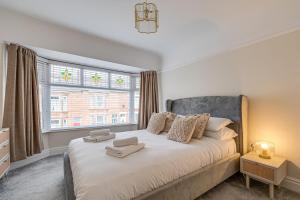 a bedroom with a large bed with a window at Elegant 3 Bed House near Liverpool City Centre in Liverpool