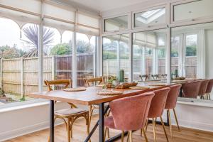 a dining room with a table and chairs and windows at Elegant 3 Bed House near Liverpool City Centre in Liverpool