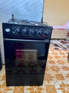 a black stove is sitting on a kitchen floor at Cozy studio apartment in Arusha