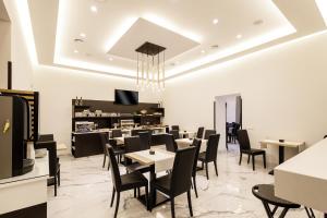 a restaurant with black chairs and tables and a counter at Best Western Hotel dei Mille in Naples