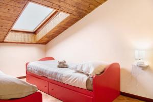 una camera con letto rosso e finestra di Cascina Noè a Ozzano Monferrato