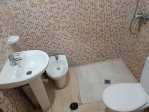 een badkamer met een witte wastafel en een toilet bij Résidence hôtelière Nour in Dakhla