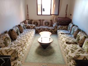 een woonkamer met een bank en een tafel bij Résidence hôtelière Nour in Dakhla