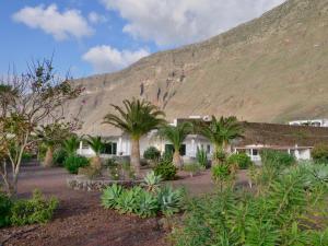 a building with palm trees in front of a mountain at Finca Afortunada in Las Puntas