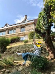 a person sitting on a swing in front of a house at On dirait le sud ! Guesthouse centre ville et vue. in Thouars