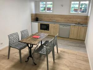 a kitchen with a wooden table and chairs in a room at On dirait le sud ! Guesthouse centre ville et vue. in Thouars