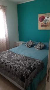 1 dormitorio con 1 cama con paredes azules en Rocio en Ushuaia