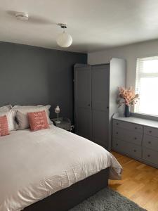 a bedroom with a bed and a dresser and a window at Modern Apartment in Trendy Dalston in London