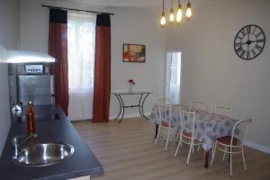 eine Küche und ein Esszimmer mit einem Tisch und Stühlen in der Unterkunft Hôtel Rapin in Portets